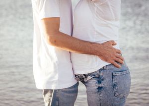 Couple embrace infront of the water at Parlee Beach, pregnancy photos, maternity photoshoot in Shediac New Brunswick, Parlee Beach photos