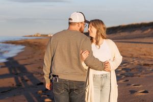 Couple embrace during sunset beach photography session, Moncton maternity photographer, pregnancy announcement photoshoot