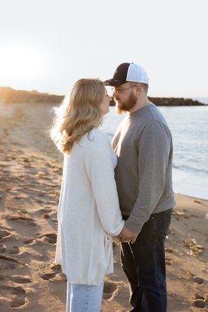 Couple hold hands at sunset during pregnancy announcement, Moncton maternity photographer, Shediac pregnancy announcement photography