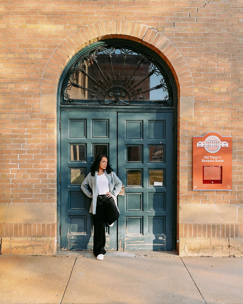 Modern casual style captured in front of an elegant arched doorway with vintage architectural details.