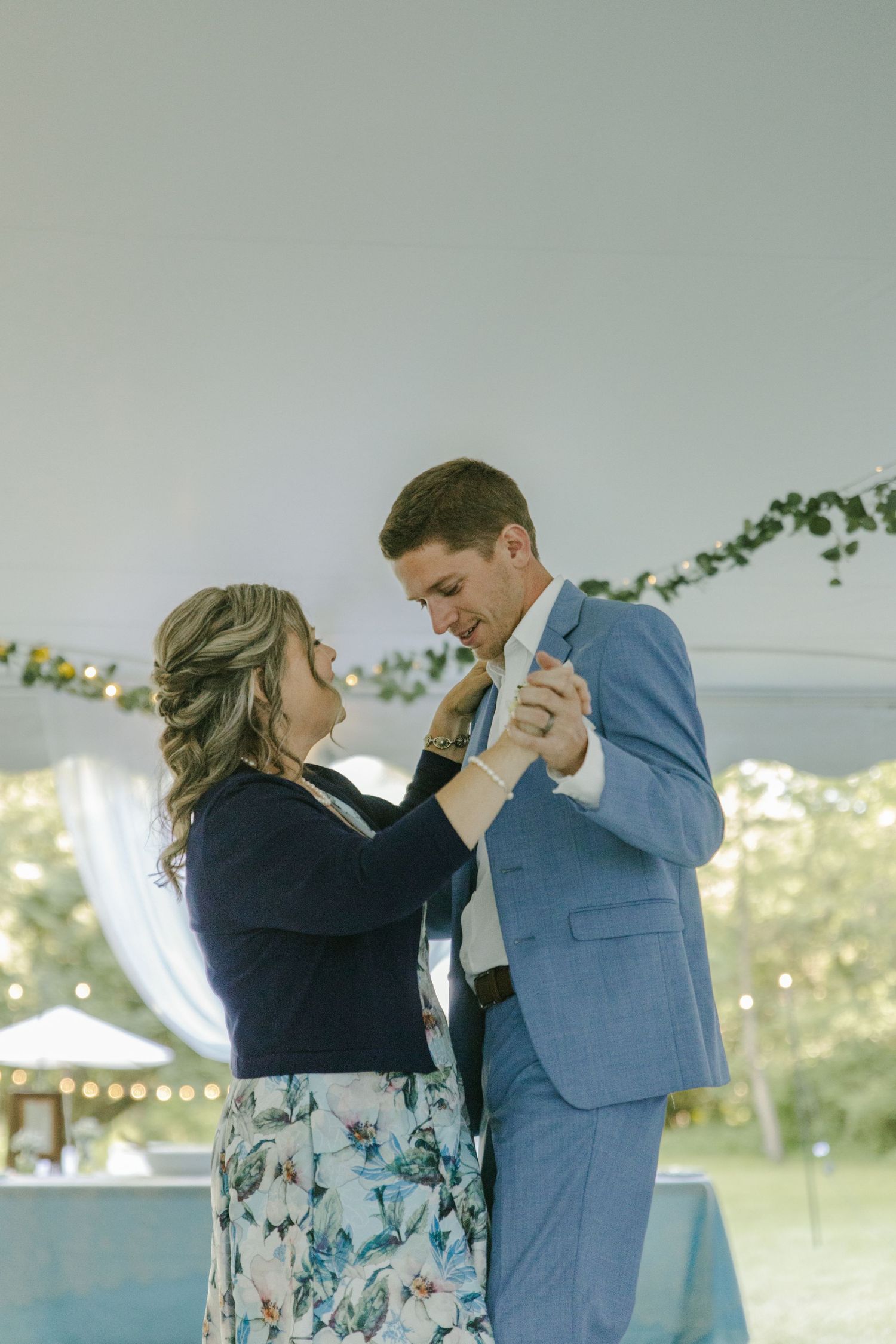 A couple dances together at their wedding reception, sharing an intimate moment.