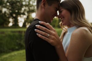 Tender moment between couple during sunset engagement photoshoot.