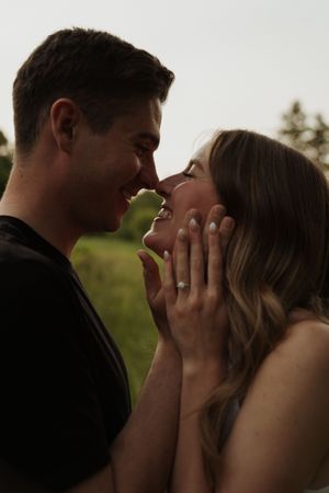 An intimate moment between a couple sharing joy and laughter in an outdoor setting.