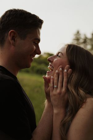 A tender moment between a couple laughing together outdoors.
