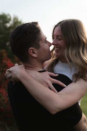 Close-up of tender embrace in outdoor garden setting with natural lighting.