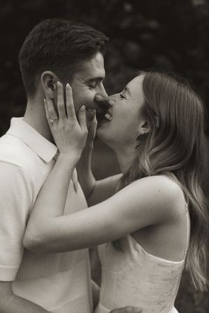 An intimate black and white portrait of a couple sharing a romantic moment in natural lighting.