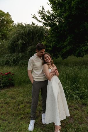 A couple shares a romantic moment together in a scenic outdoor garden setting.