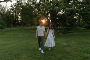 A romantic couple shares a tender moment in a scenic park setting at dusk.