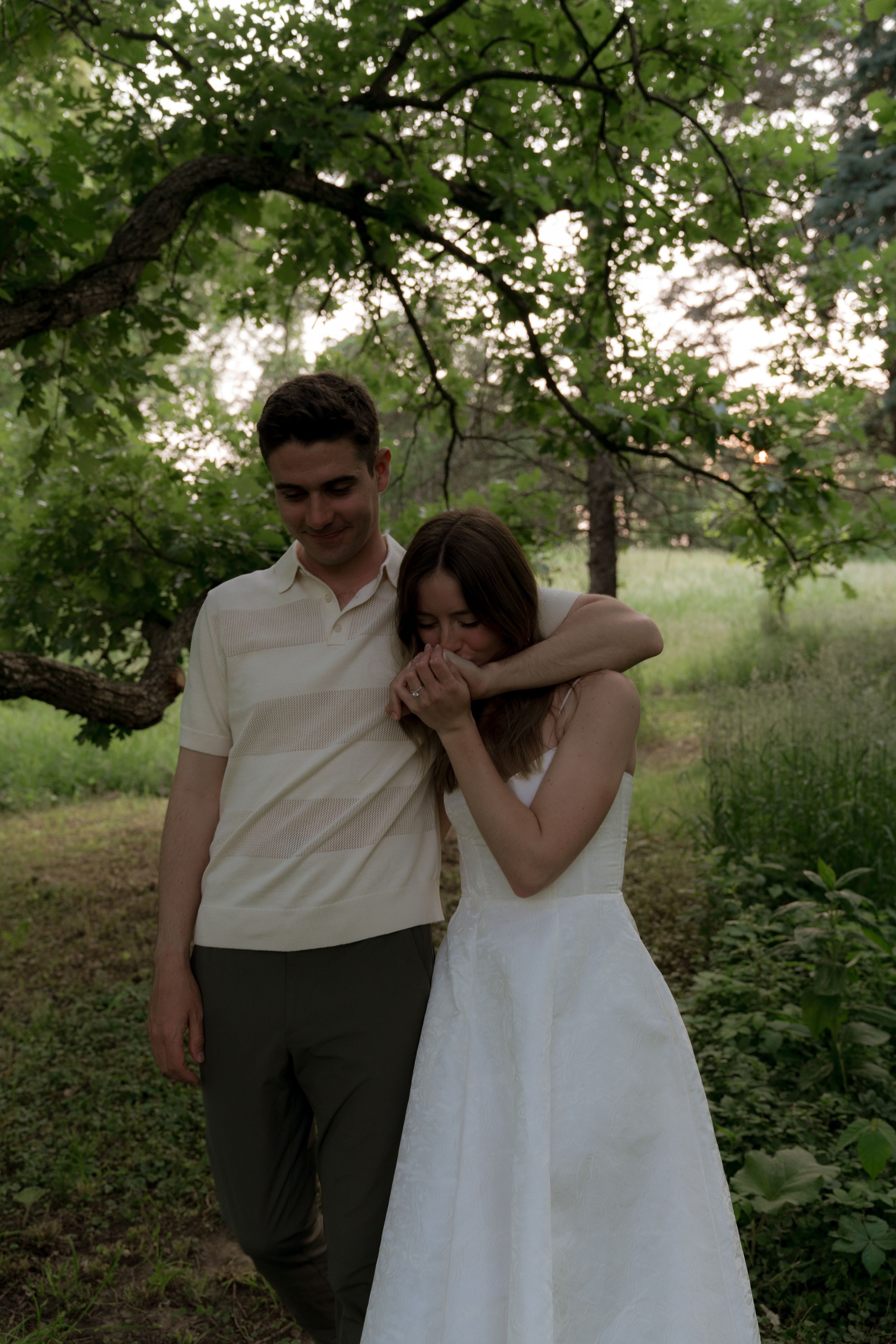 A tender embrace captured in a lush green garden setting.
