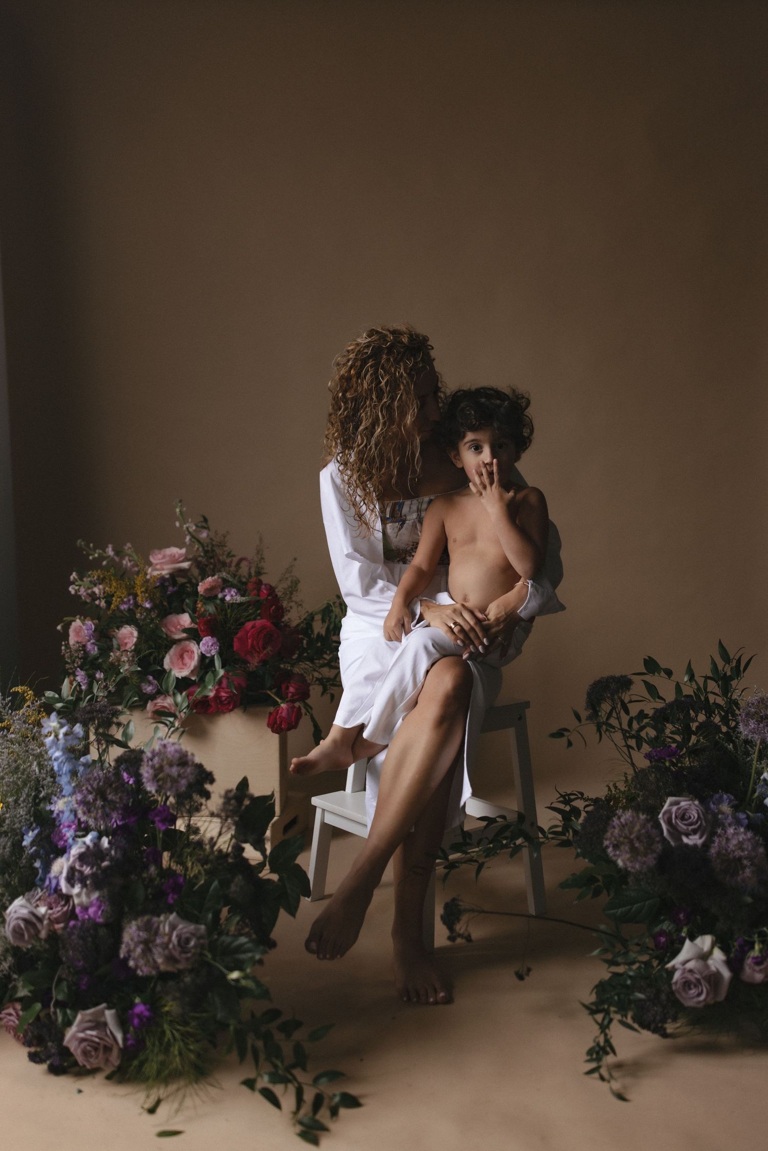 Artistic boudoir photography series with floral arrangements featuring roses and foliage against a dark moody background.