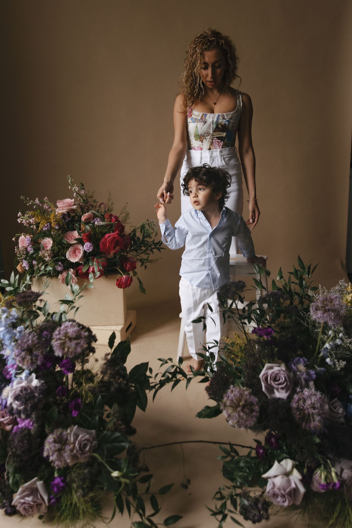A series of romantic floral photos with white dress against a backdrop of pink and purple blooms in moody lighting.