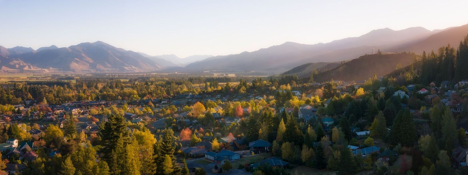 Sweeping vista of mountains and valleys with fall colors in the forest canopy.