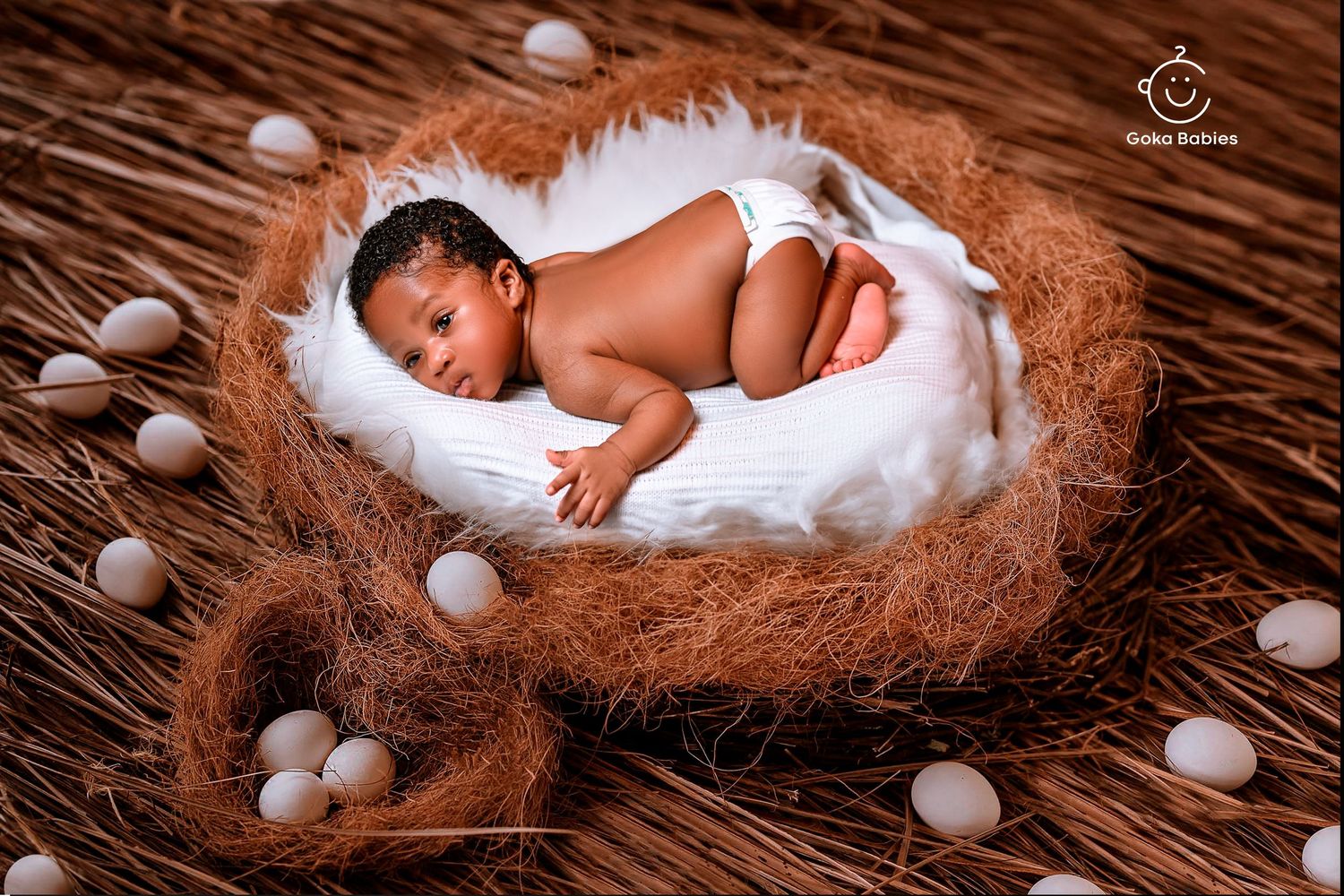 Sleeping newborn on white fur nest with decorative pearls.