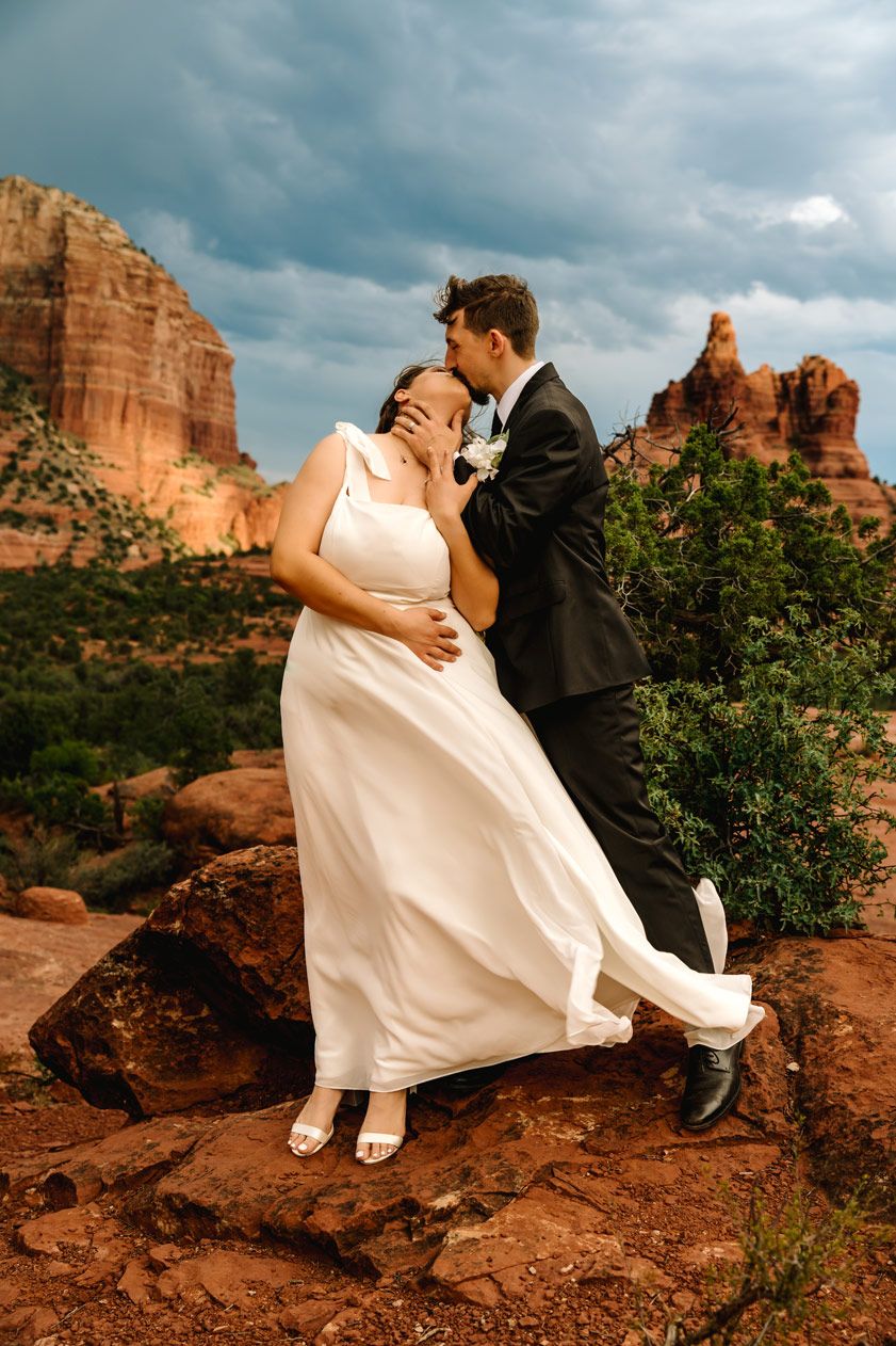 Romantic wedding photo against dramatic red rock formations in Sedona.