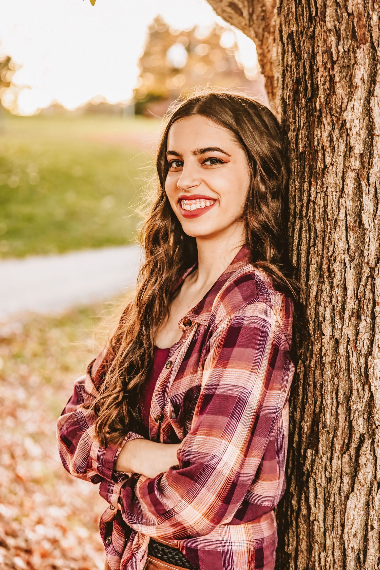 Portrait against a tree trunk with autumn colors in the background.