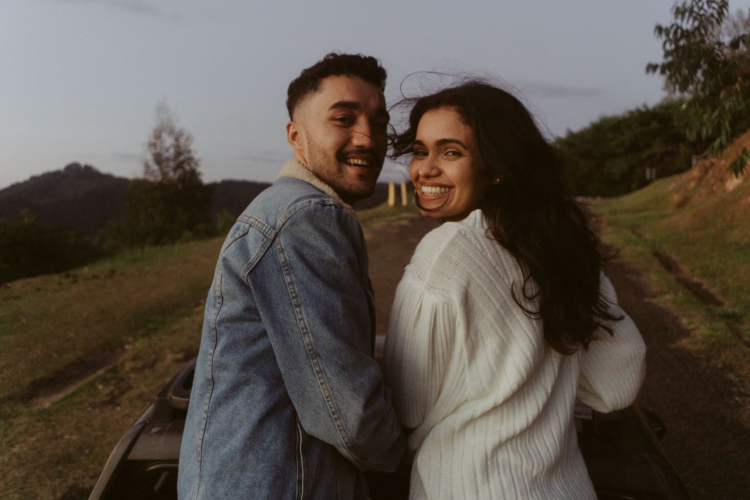 Casal olha para câmera em sessão de fotos em Campos do Jordão
