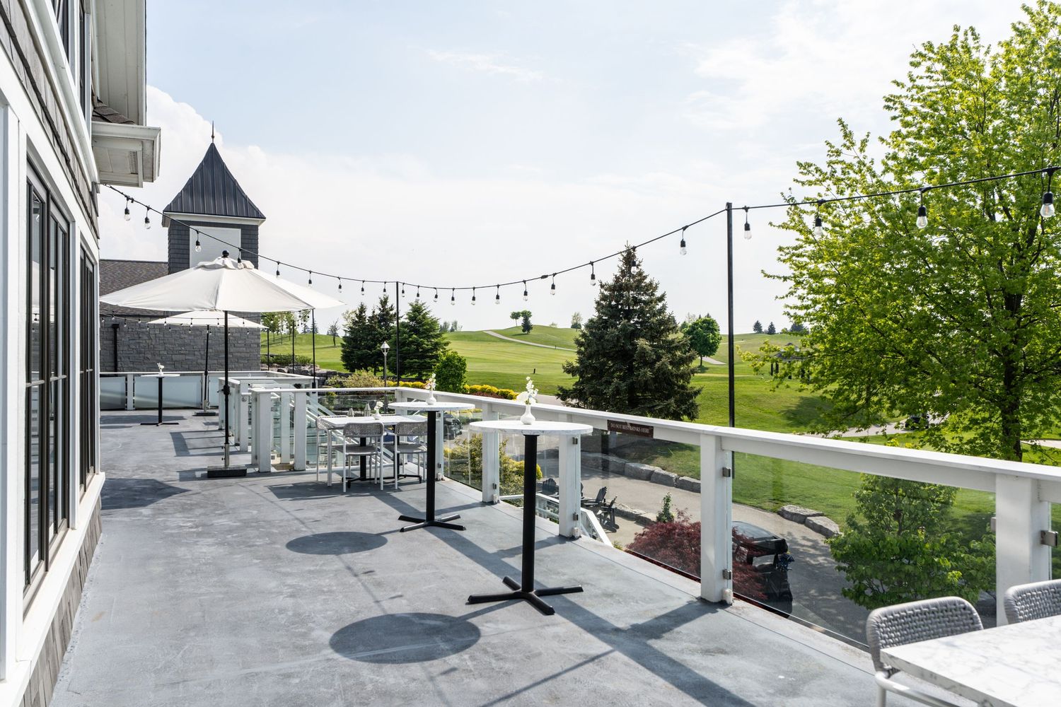 Spacious outdoor patio with string lights and modern seating arrangements at Whistlebear Golf Club.