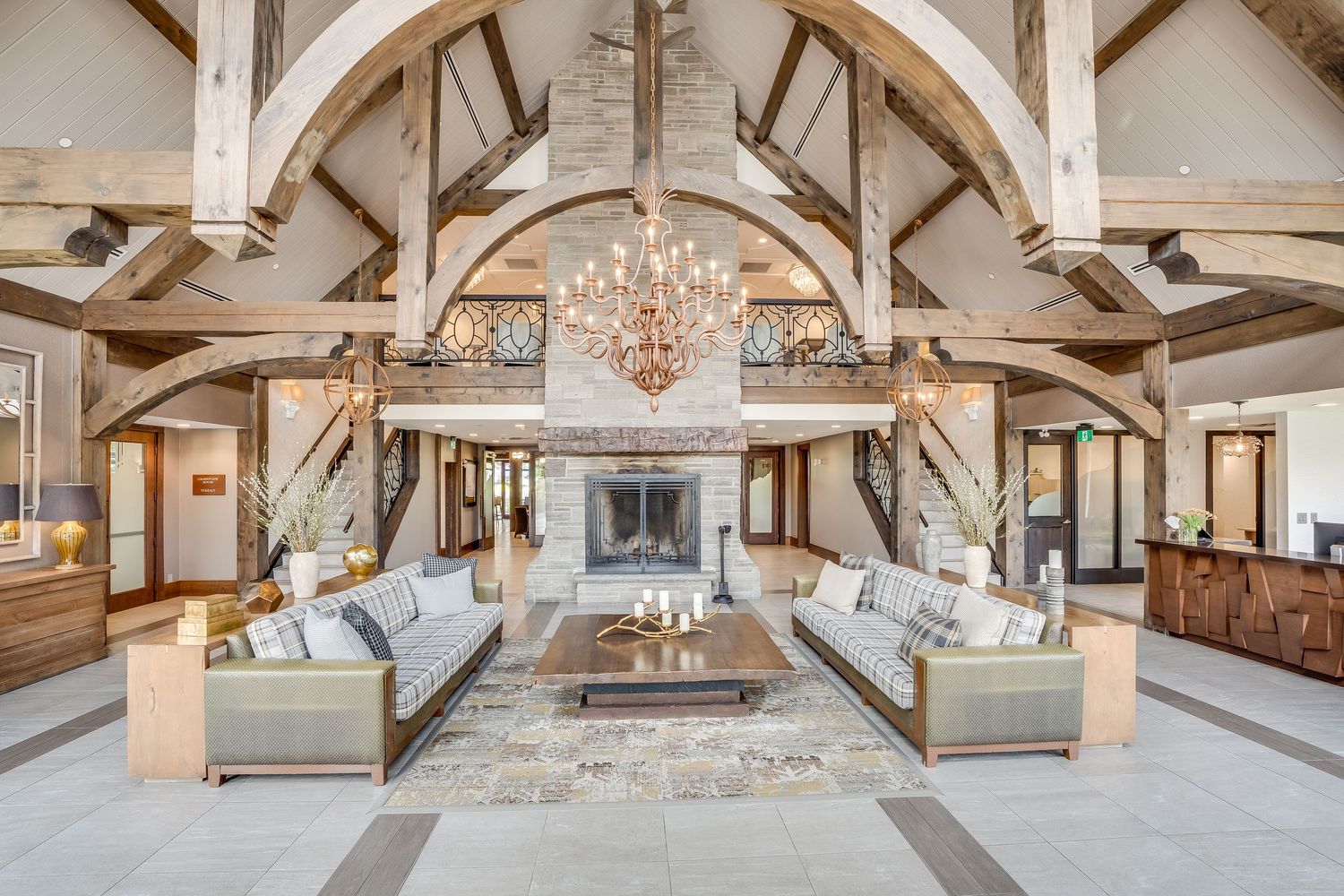 Rustic wooden beam cathedral ceiling at Whistlebear Golf Club with elegant chandeliers in a renovated event space.