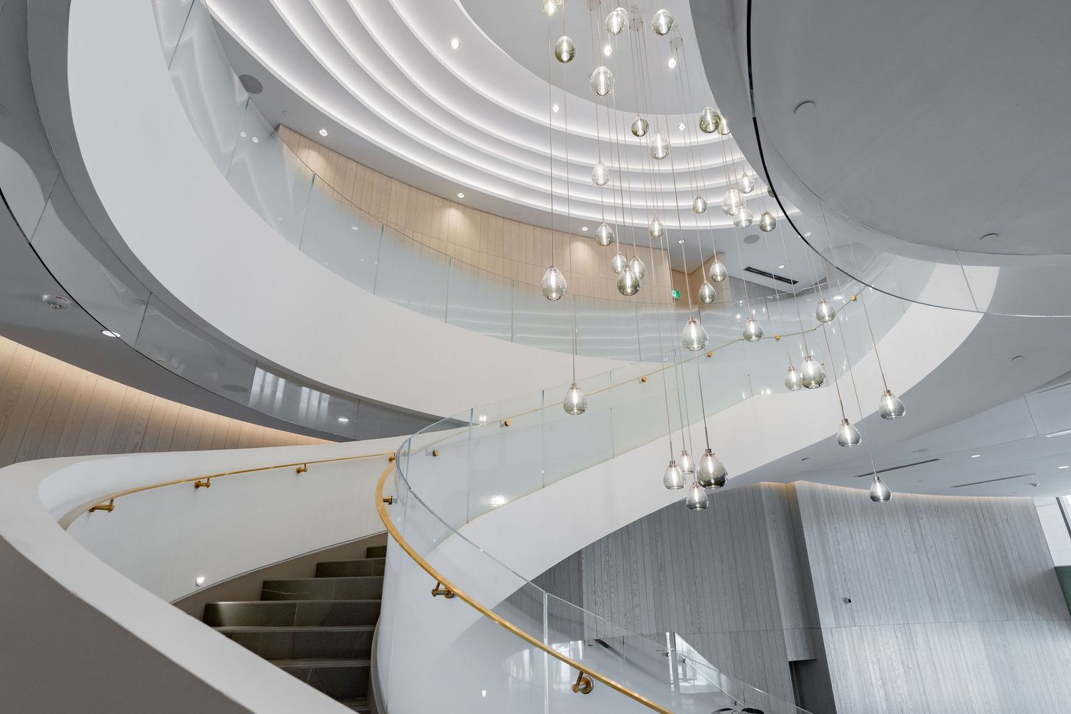 Contemporary ceiling design with curved white panels and hanging crystal light fixtures.
