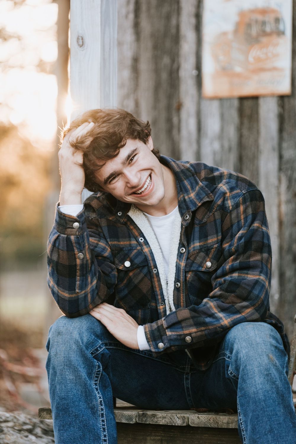 A series of candid outdoor senior portraits showing someone wearing a plaid flannel and jeans sitting on rustic wood.