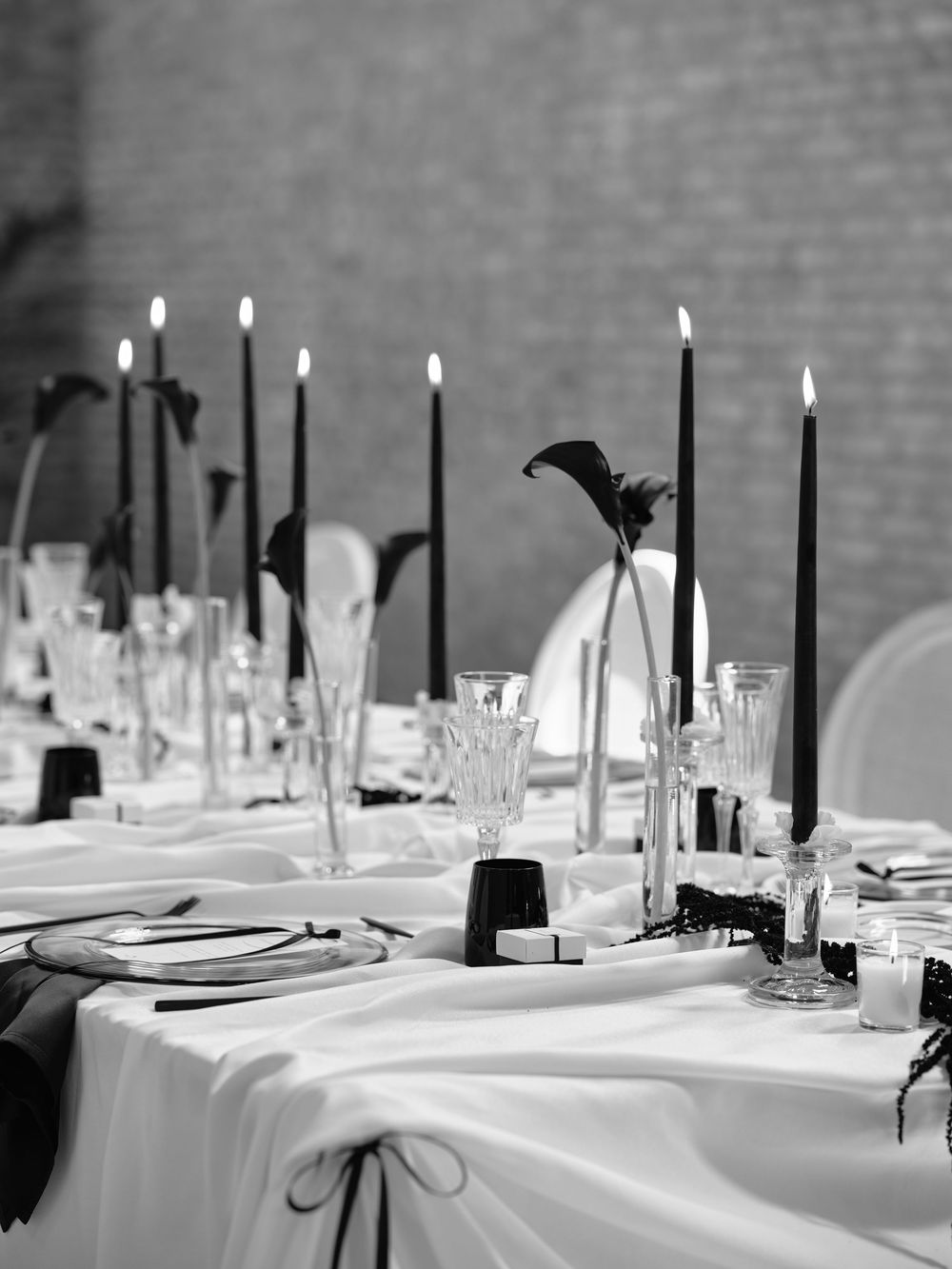 Black and white table setting with tall candles and minimalist floral arrangements. Photoshoot by Venice Photographer Alina Indi