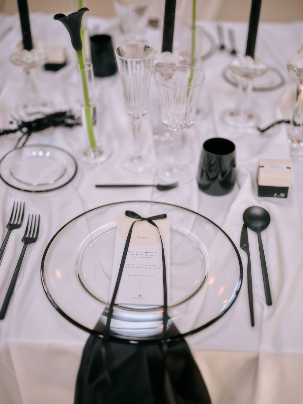 Black and white table settings with clear glass plates and modern black cutlery. Photoshoot by Venice Photographer Alina Indi
