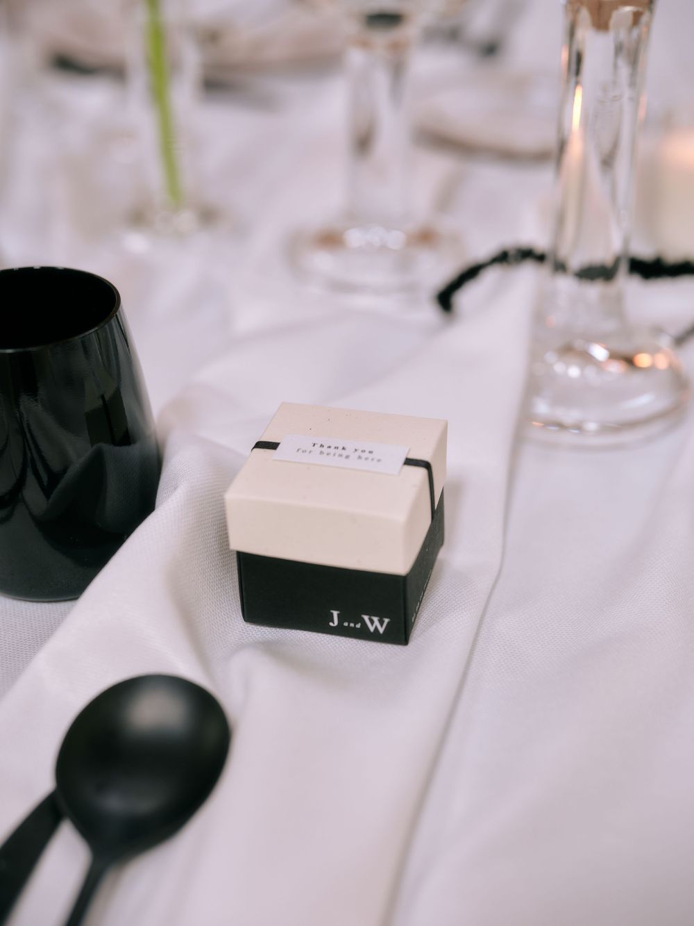 Wedding favor boxes with monogram J+W displayed on elegant white tablescapes. Photoshoot by Venice Photographer Alina Indi