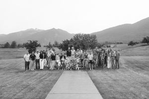 Large group of people gathered outdoors with mountains in the background.