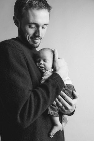 Black and white portrait series showing tender moments between parent and baby.