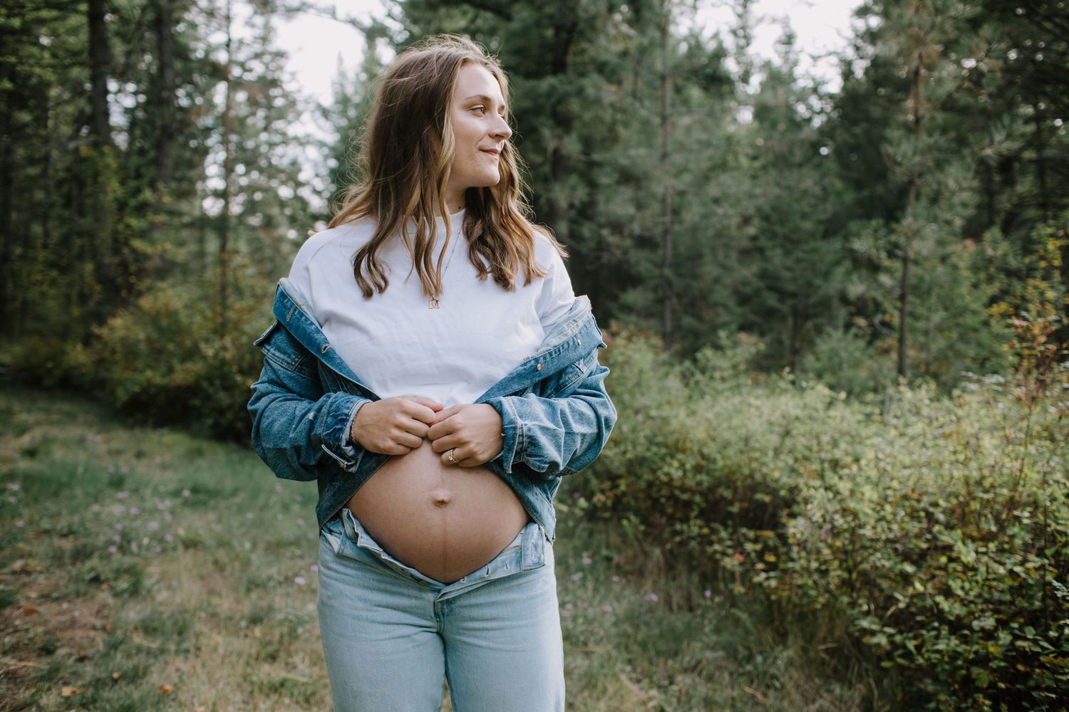 Maternity photoshoot in forest setting with soft natural lighting.