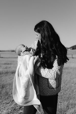A tender black and white portrait of nurturing care in a natural outdoor setting.