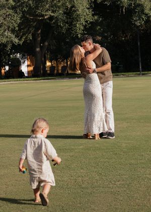 A playful scene unfolds on a grassy lawn with people in white outfits enjoying a sunny day.