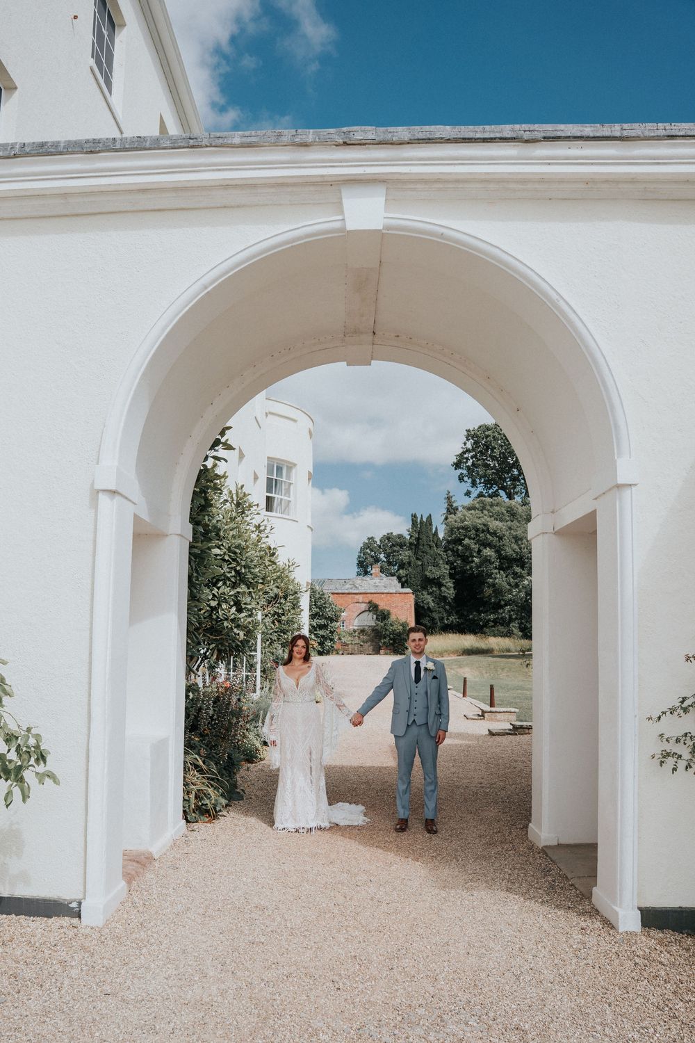 Bride and Groom portrait in teh arch of Rockbeare Manor