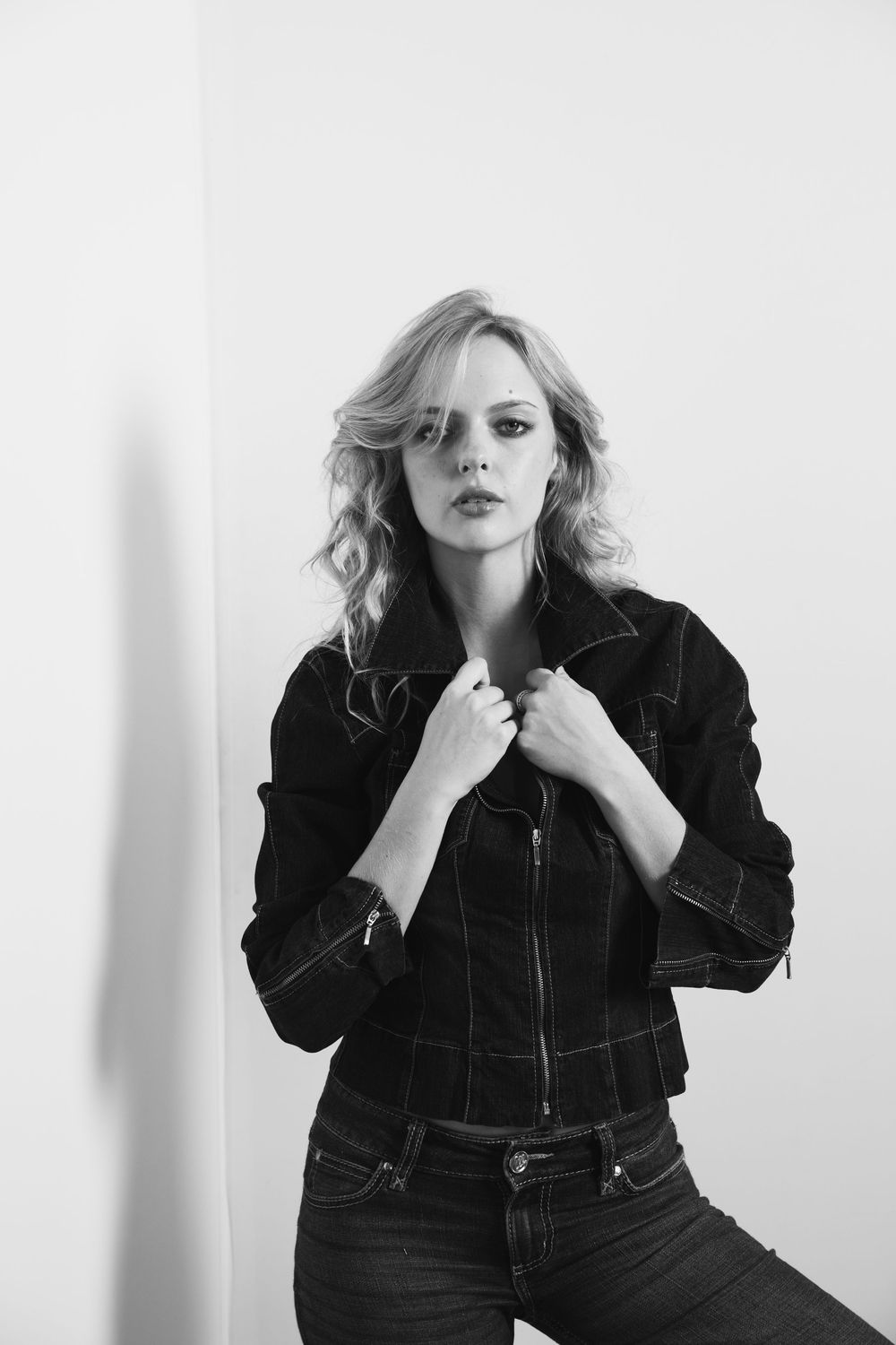 Black and white fashion portrait series in denim jacket against white background.