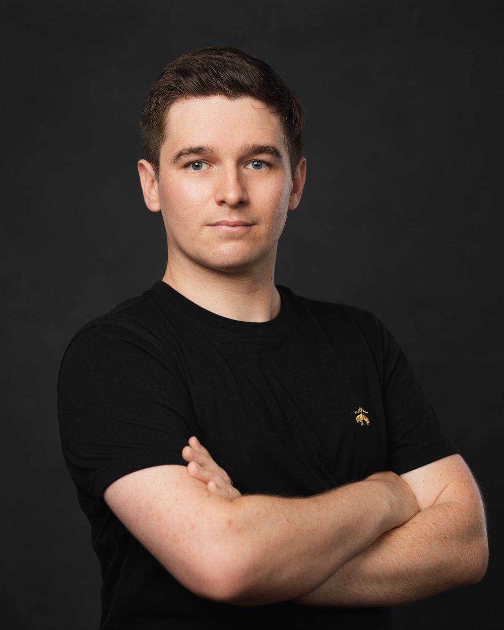 Studio portrait series featuring person in black t-shirt with crossed arms.