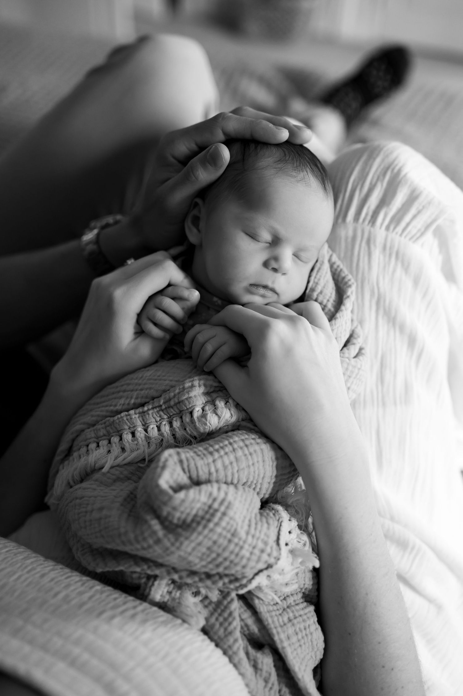 Black and white series of a sleeping infant being tenderly held created by Storms Photography in Pennsylvania.