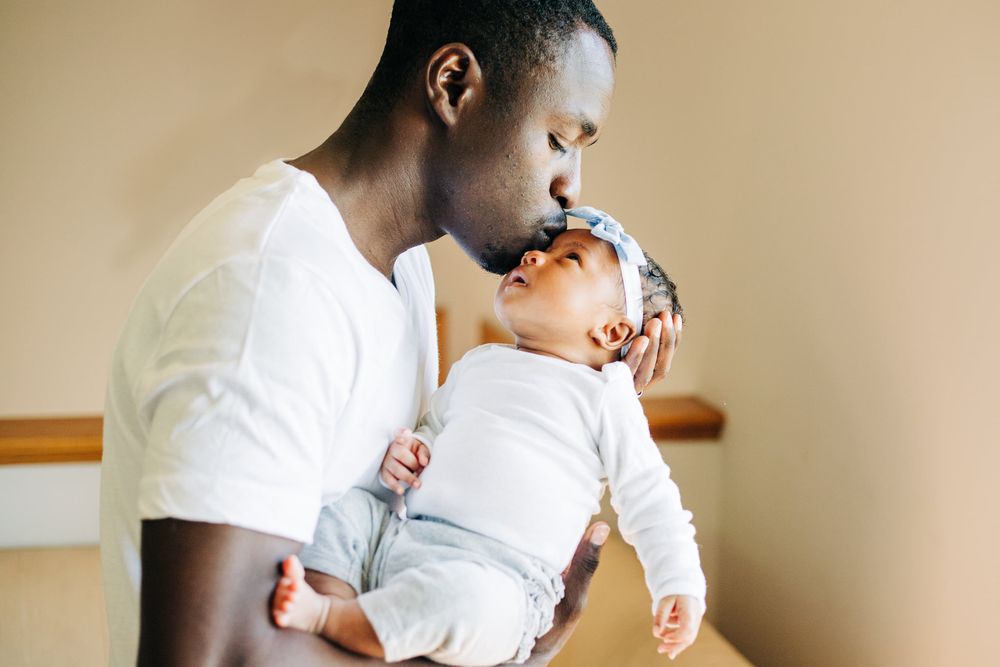 father kisses baby's head