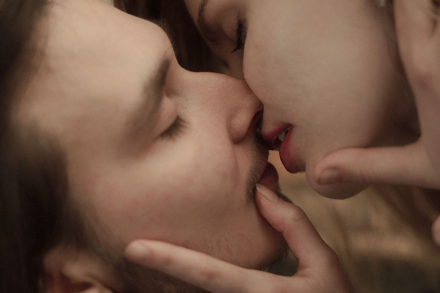 Close up portraits of intimate couples kissing with dramatic lighting and soft focus effects.
