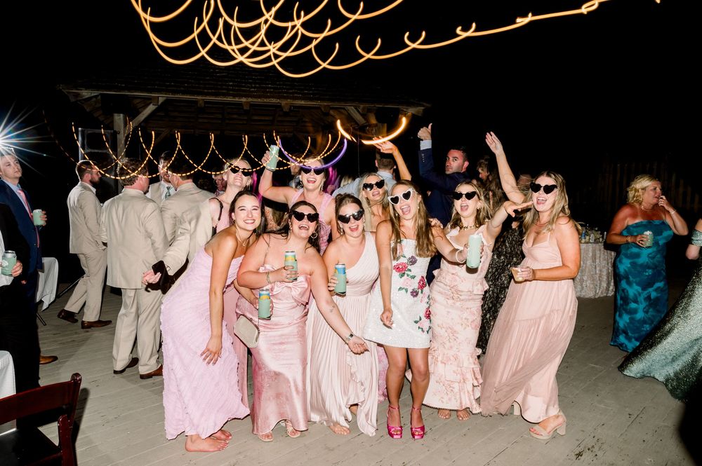 Wedding guests dancing together on the dance floor during a reception celebration in formal attire.