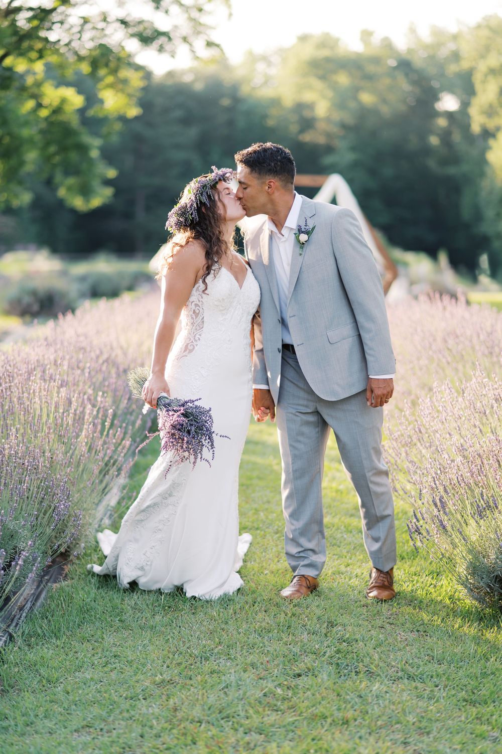 A romantic couple shares intimate moments in a blooming lavender field on a sunny afternoon.