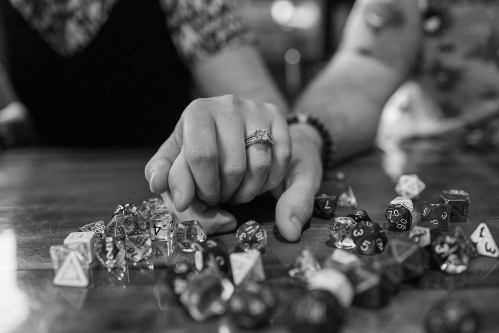 A close-up view of chess pieces being moved during a game on a traditional black and white board.