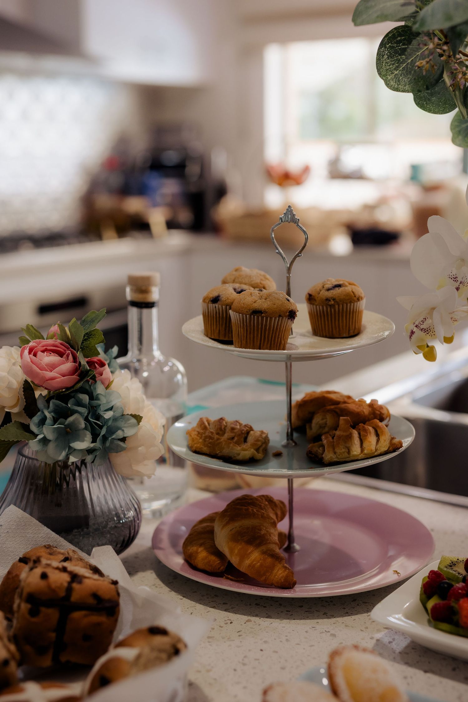 An assortment of chocolate chip cookies and baked pastries displayed on plates at a dessert table setting.