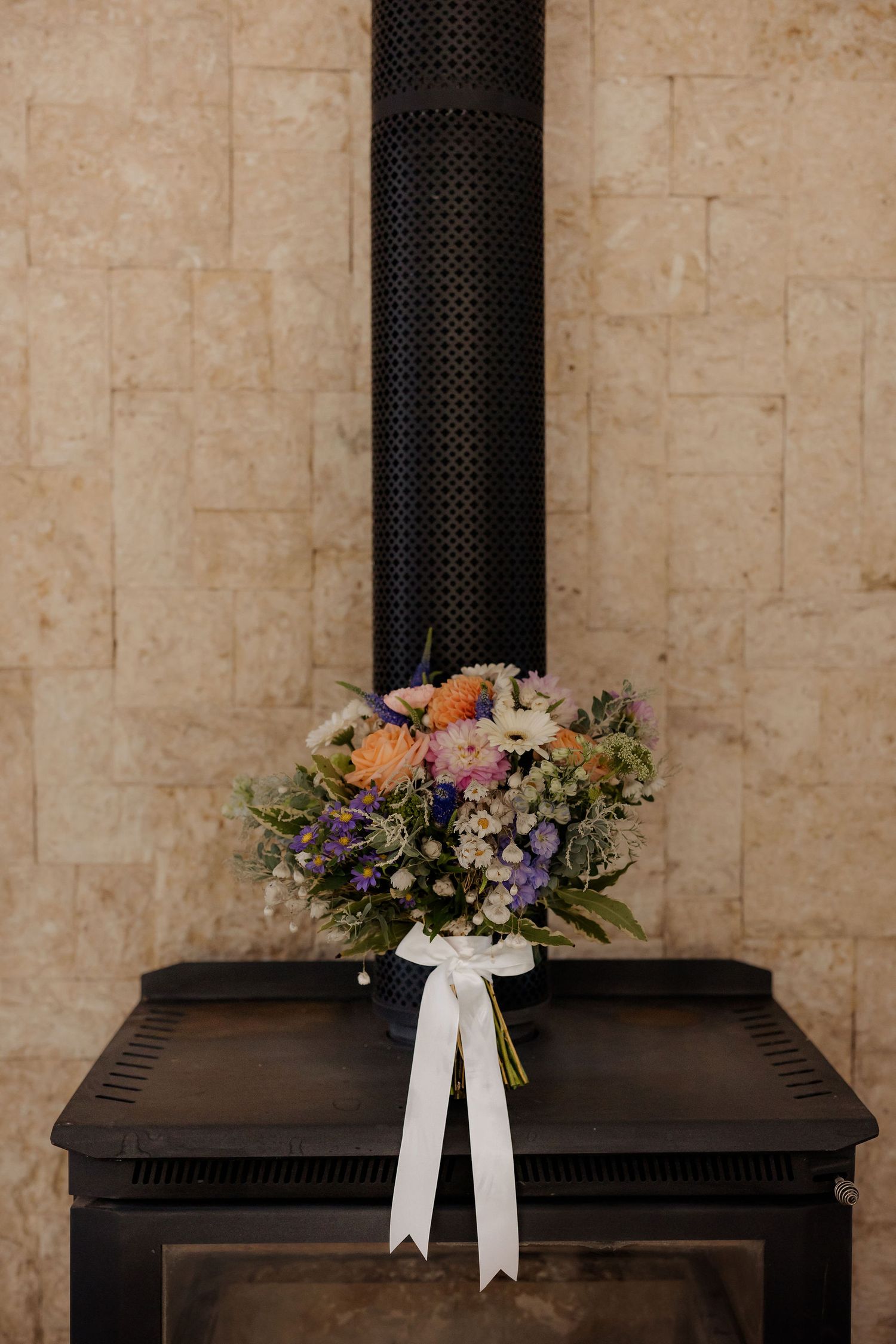 A black cremation urn decorated with floral arrangements and a white ribbon shown in multiple identical frames.