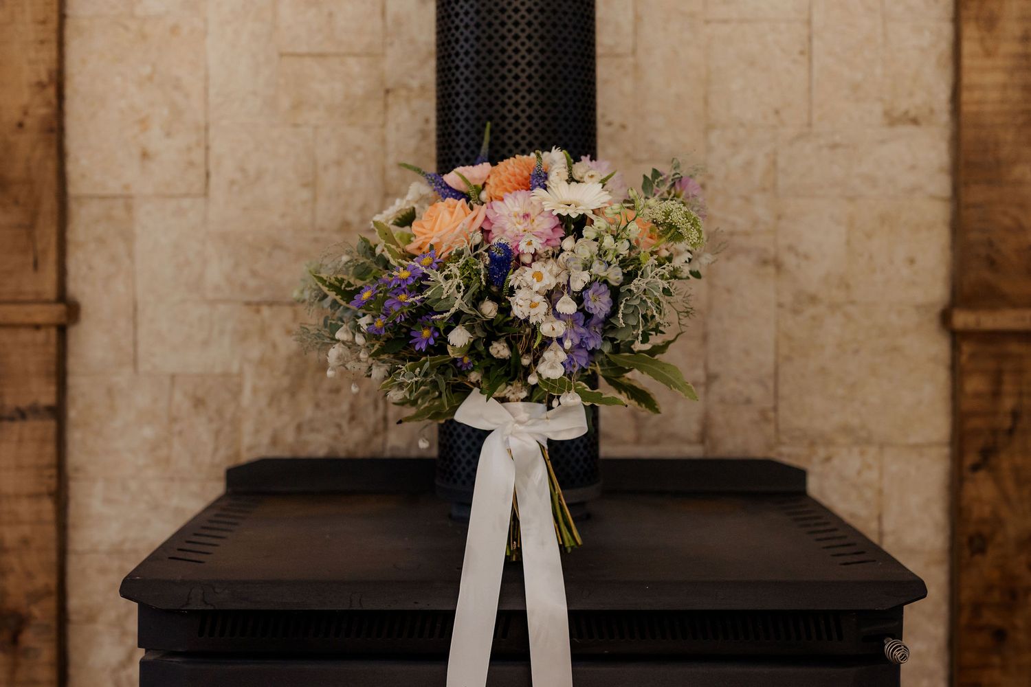 A rustic church sanctuary with wooden pews and floral decorations including white ribbons and pastel flower arrangements.