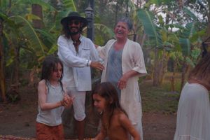 A group gathers for a celebratory moment in a lush garden environment.