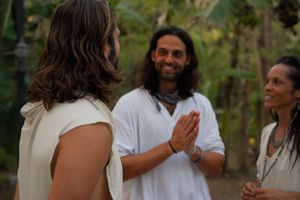 A group shares an intimate conversation in a lush garden setting.
