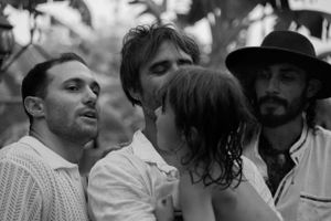 Black and white photo of an intimate group conversation outdoors.