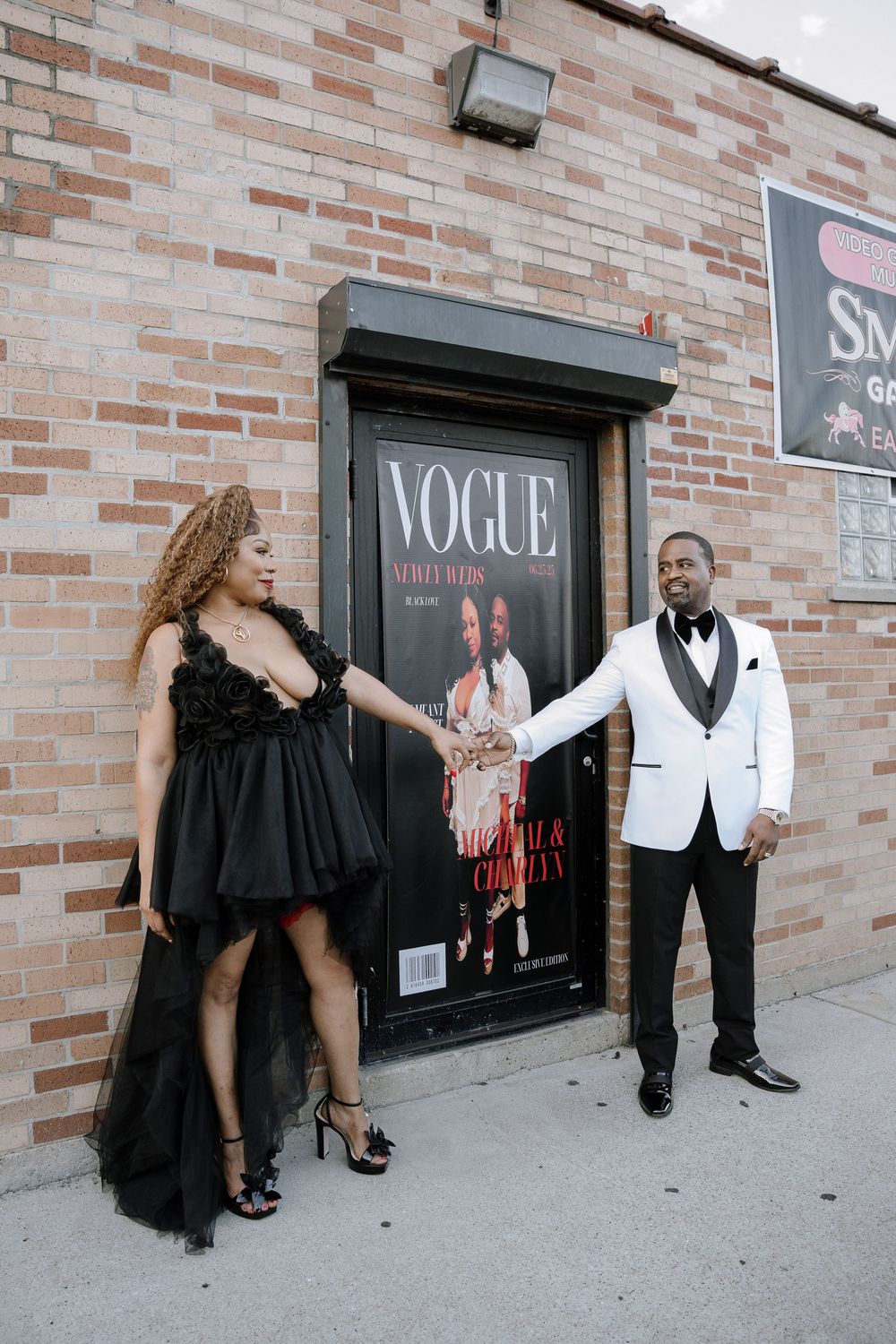 Couple in formal attire posing against brick wall with Vogue signage in series of candid moments.