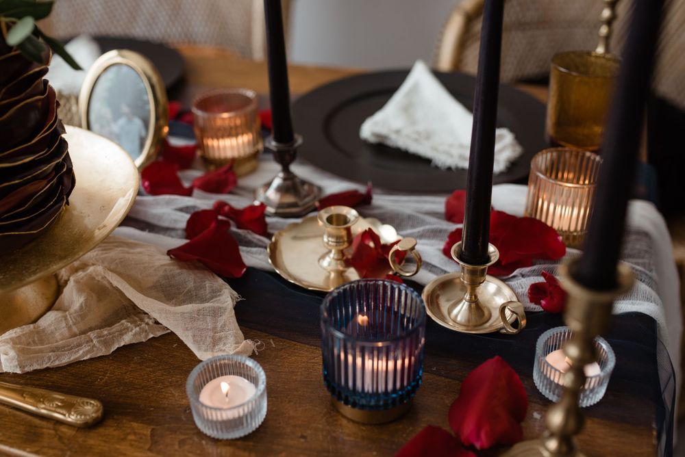 Elegant table setting with candleholders, red napkins and vintage decor for intimate wedding dinner.