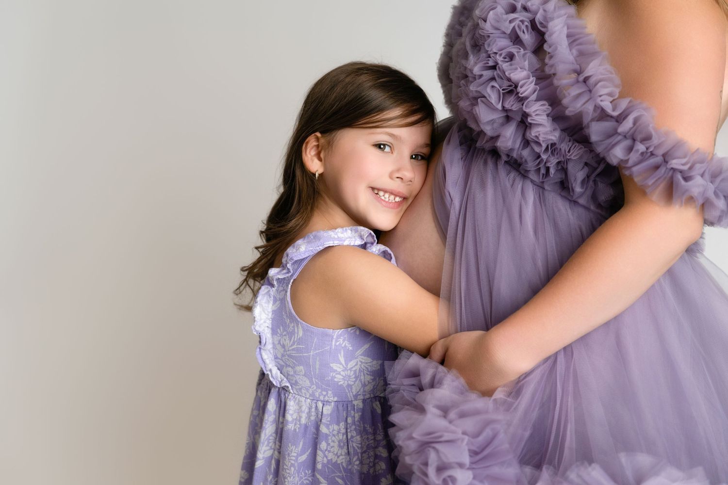 A child in a purple ruffled dress poses elegantly while dancing and twirling in different positions.